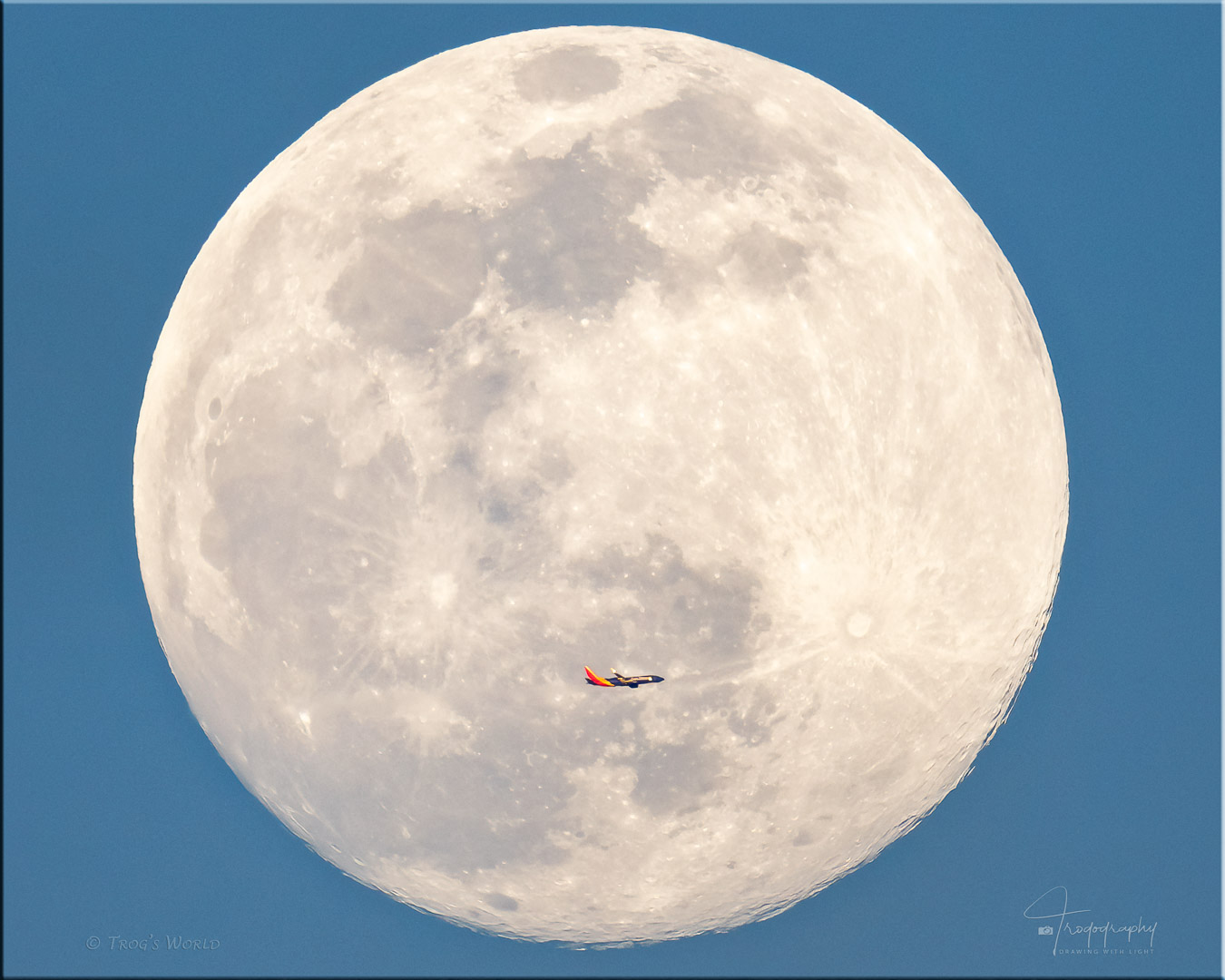 Plane flies in front of a full moon